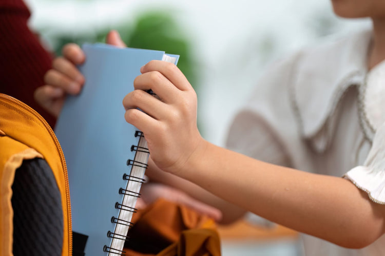 A student puts a notebook in the school bad